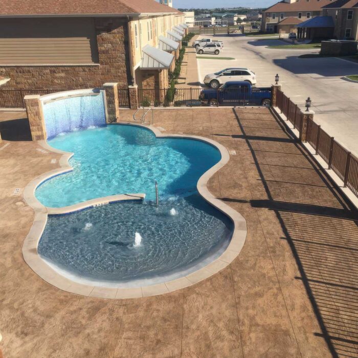 Apartment complex pool with organic shape that was designed and built by Optima Pools in Texas.