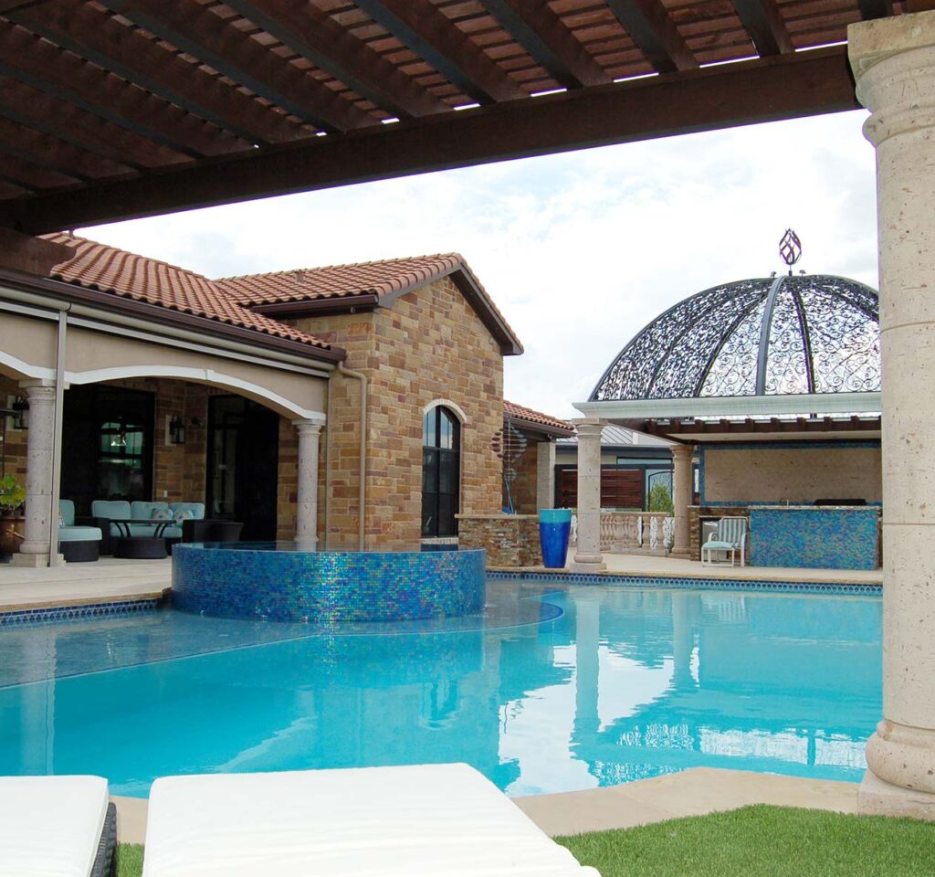 Beautiful pool construction with filigree dome over outdoor bar, pergola covered lounging area.