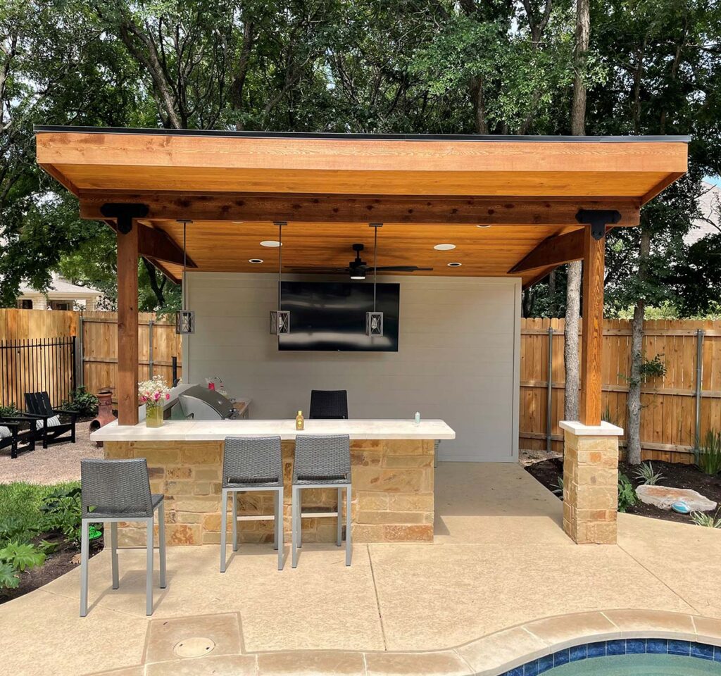 Outdoor bar and kitchen with built in grill near the pool.